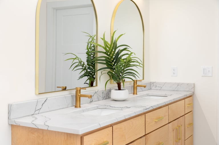 Modern double vanity bathroom with white marble and gold faucets